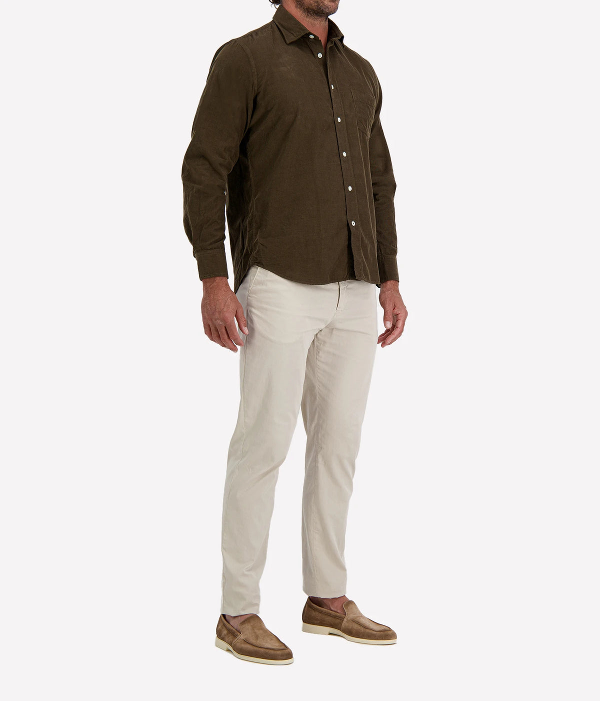 Man wearing Hartford Paul Fine Corduroy Shirt in Olive with stone chinos and brown suede shoes, three-quarter view