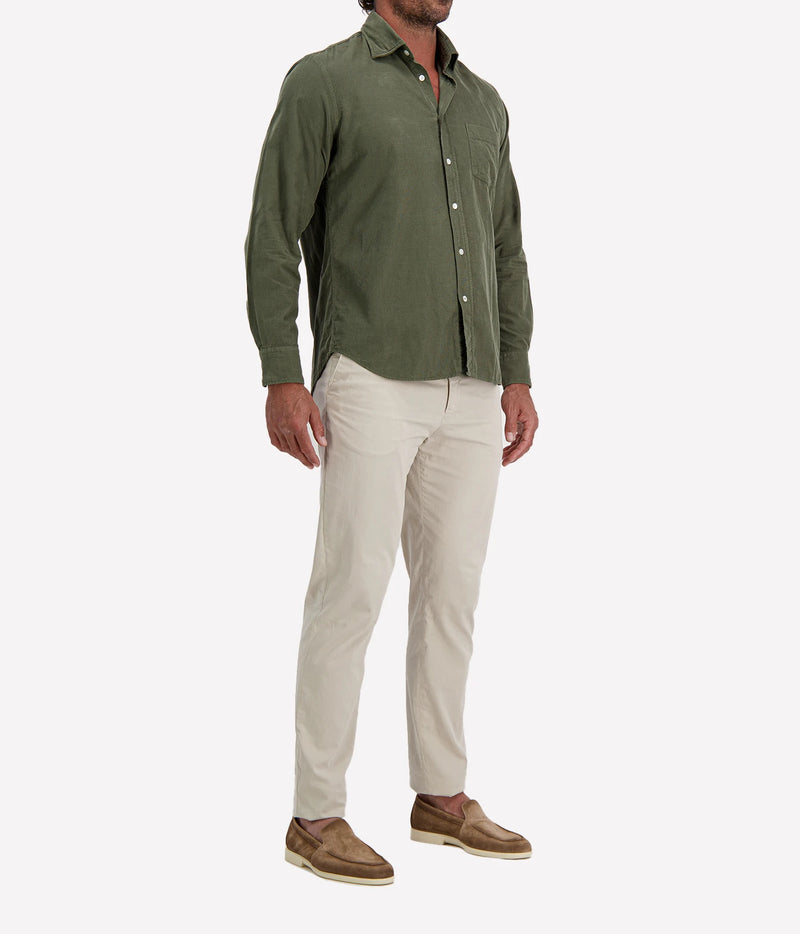 Man wearing Hartford Paul Fine Corduroy Shirt in Military with stone chinos and brown suede shoes, three-quarter view