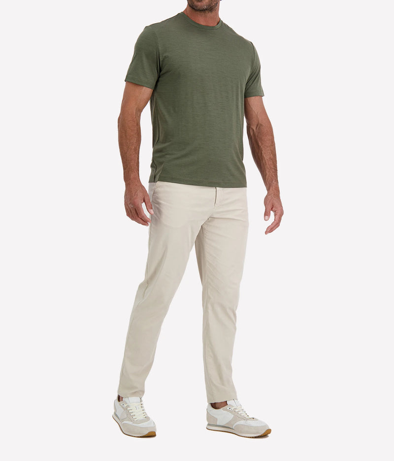 Man wearing Maurizio Baldassari Linate Short Sleeve T-Shirt in Dark Olive with stone trousers and white sneakers, angled front view