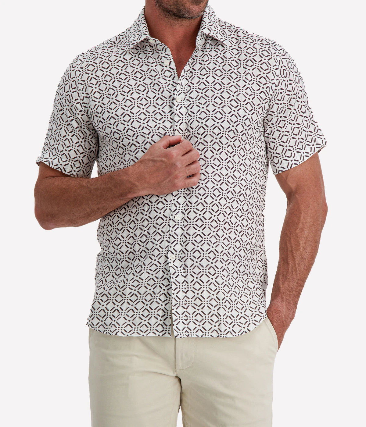 Man wearing Osvaldo Trucchi Linen Short Sleeve Shirt in Brown Geo Diamond Print with stone shorts, cropped front view