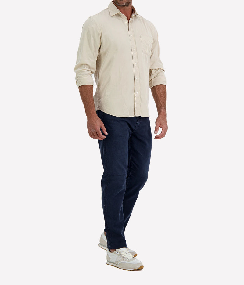 Man wearing Hartford Paul Tencel & Cotton Shirt in Stone with indigo jeans and white sneakers, angled front view with hand in pocket