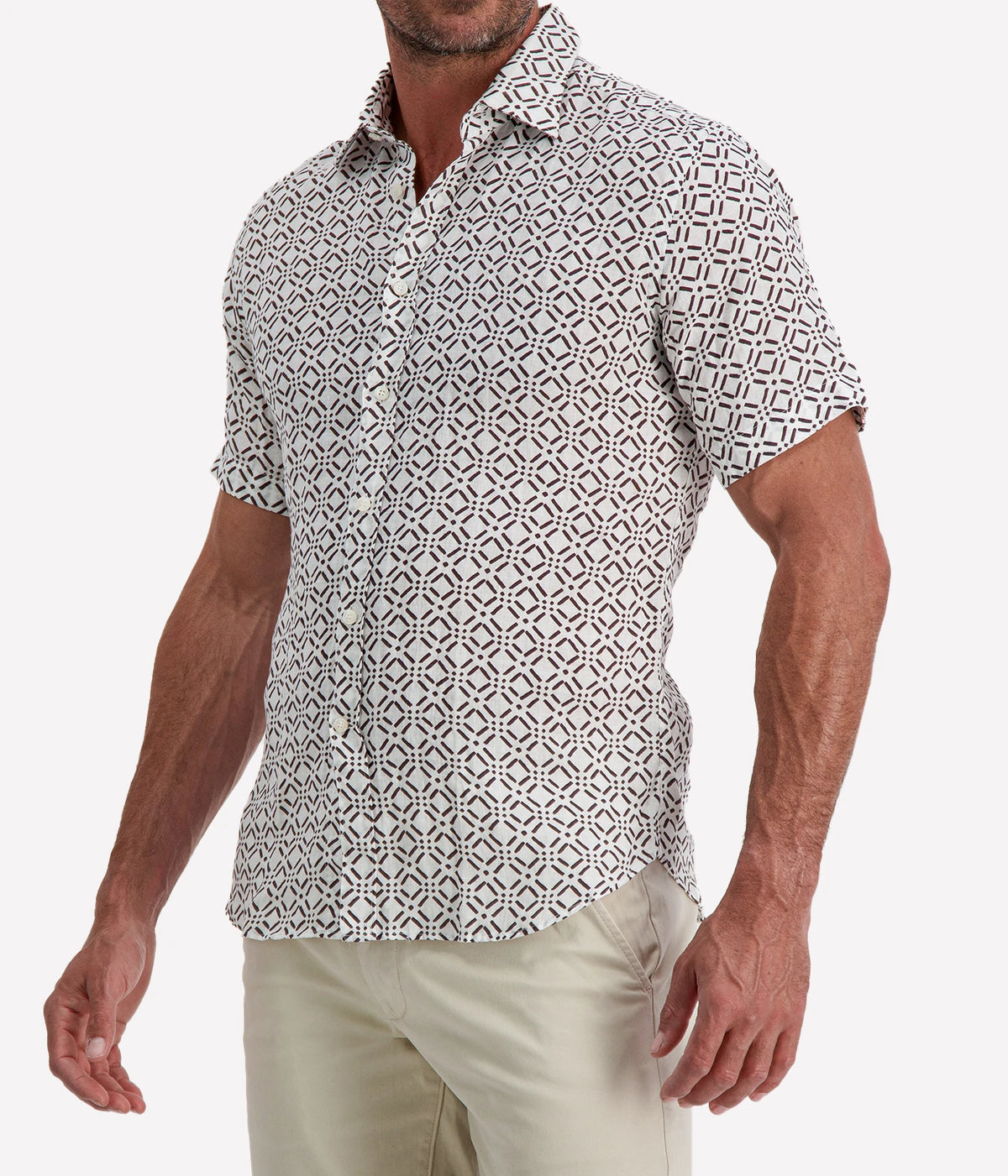 Man wearing Osvaldo Trucchi Linen Short Sleeve Shirt in Brown Geo Diamond Print with stone shorts, cropped three-quarter view
