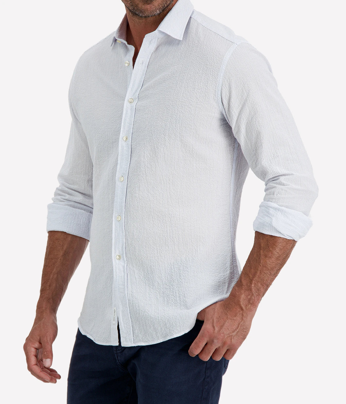 Man wearing Ingram Slim Fit Shirt in Seersucker Blue & White Stripe with indigo jeans, cropped angled front view with hand in pocket