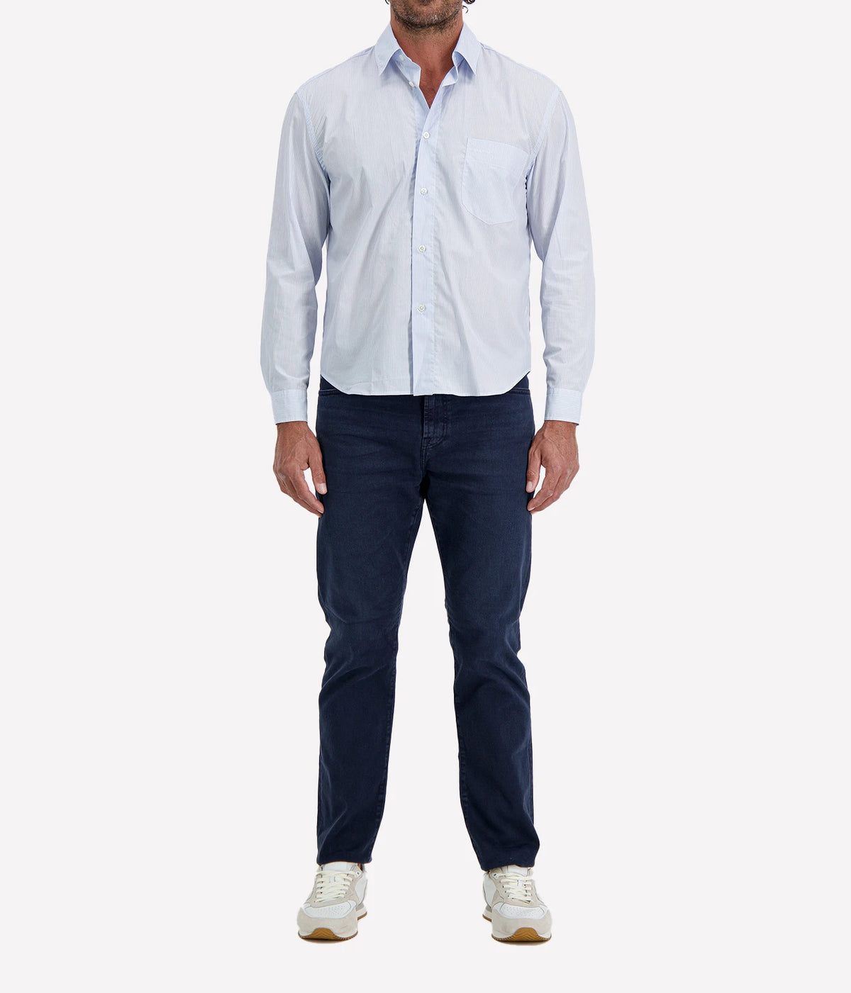 Man wearing Lardini Cotton Pocket Shirt in Blue Stripe with indigo jeans and white sneakers, full-length front view