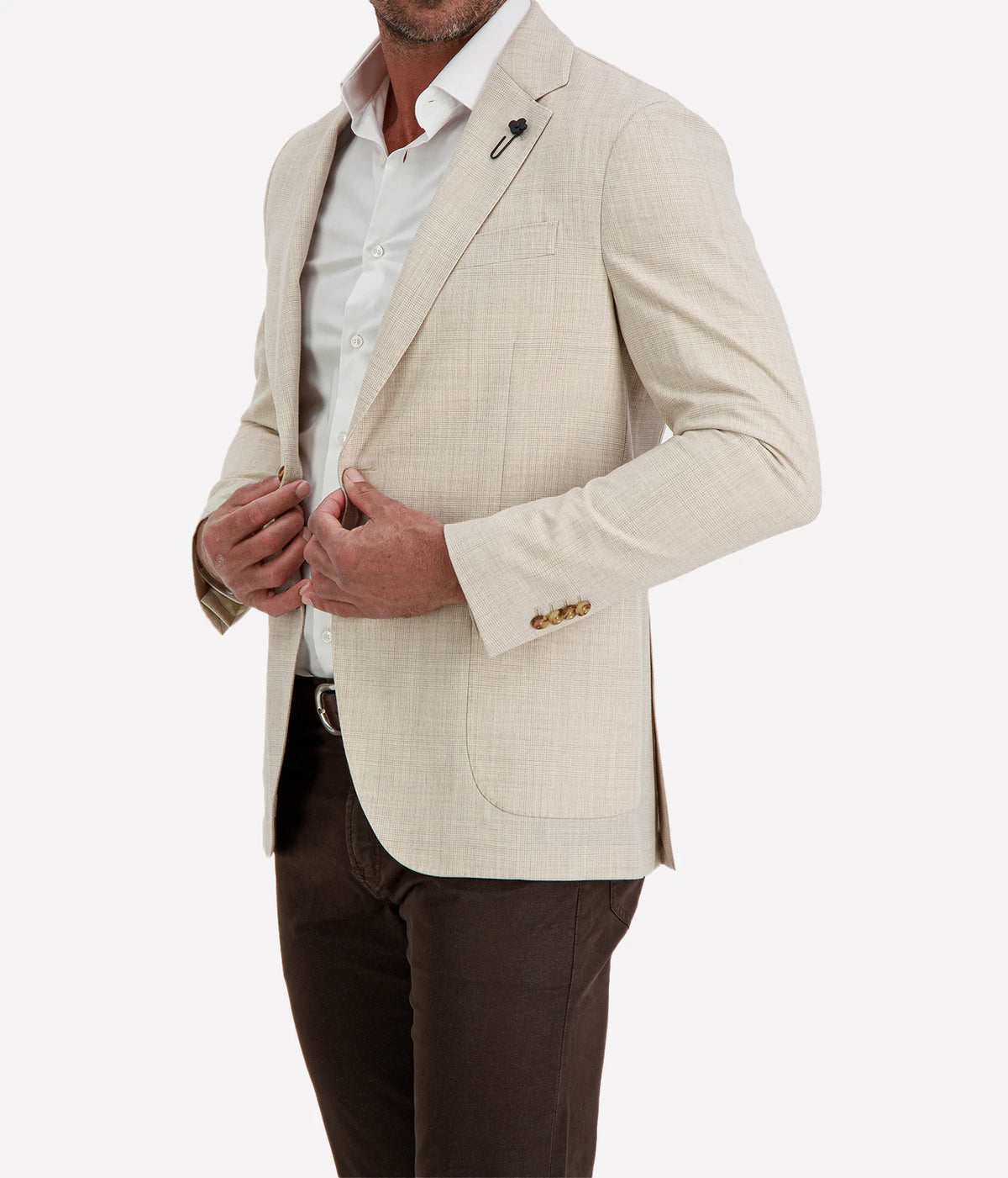Man wearing Lardini Iconic Jacket in Beige Check with a white shirt and dark brown trousers, showing the flower lapel pin, patch pockets and four-button cuffs