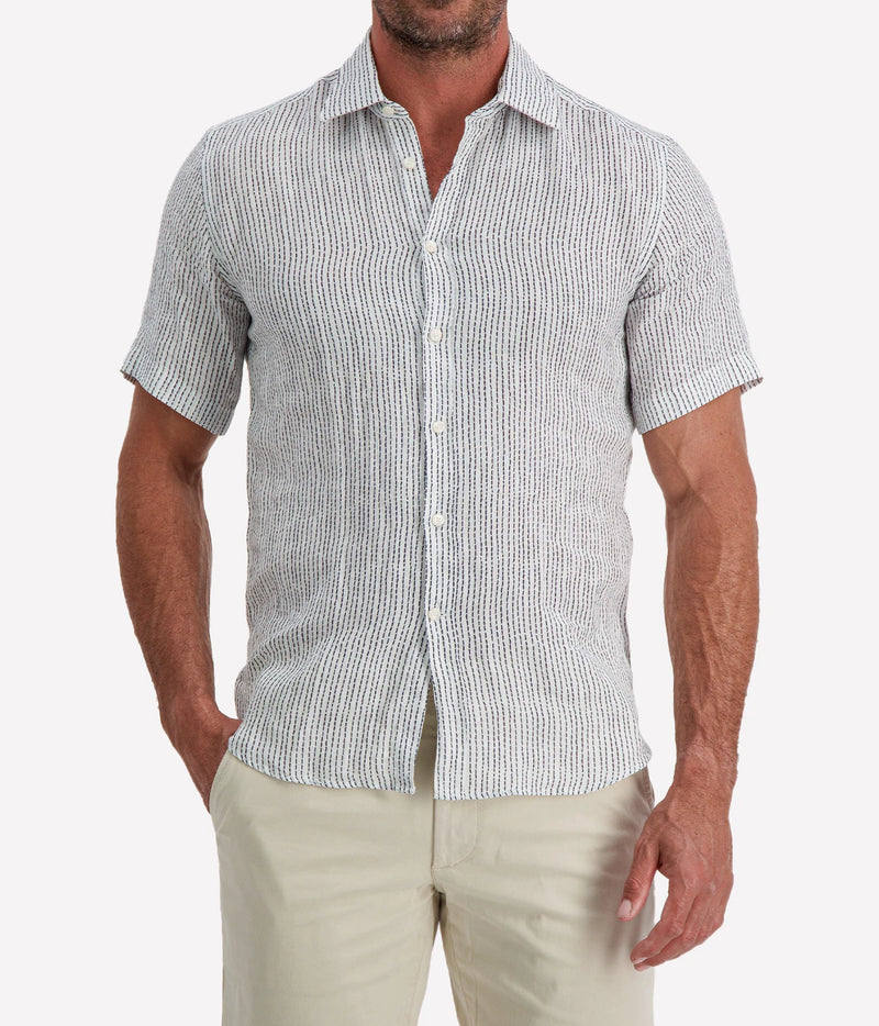 Man wearing Osvaldo Trucchi Linen Short Sleeve Shirt in Navy Woven Stripe with stone shorts, cropped front view