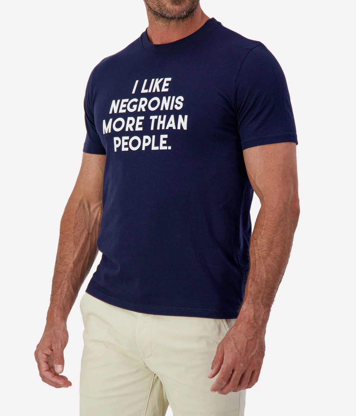 Man wearing The Refined Spirit I Like Negronis More Than People Tee in Navy with stone shorts, cropped angled front view