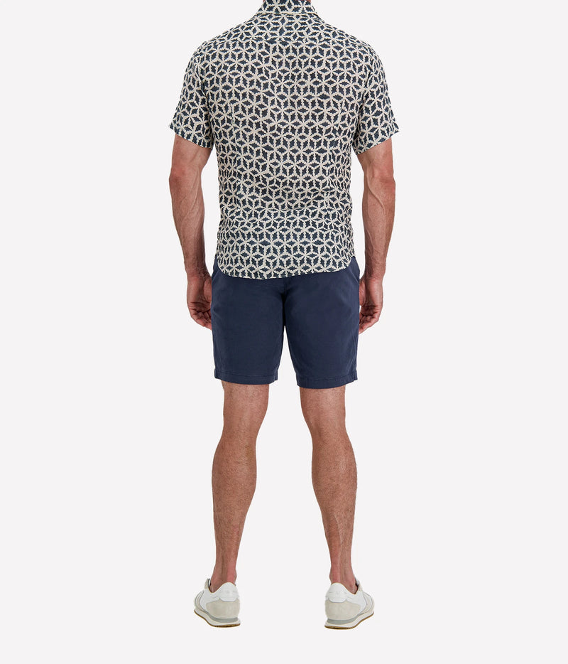 Back view of man wearing Osvaldo Trucchi Linen Short Sleeve Shirt in Navy Geo Star Print with navy shorts and white sneakers