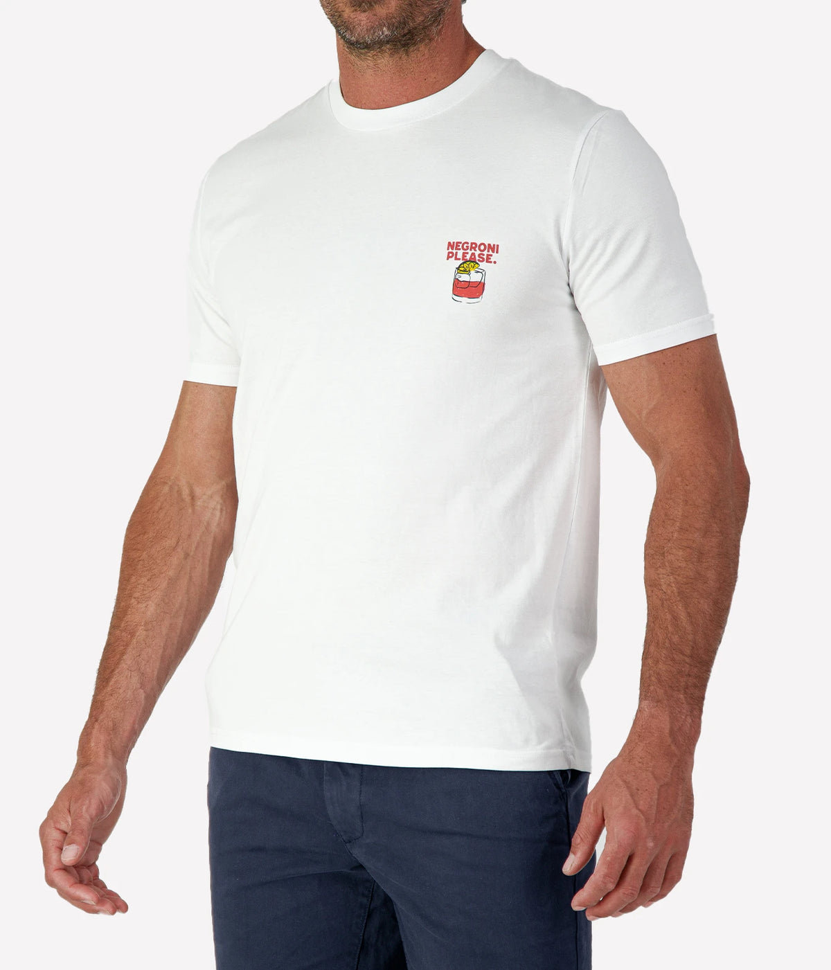 Man wearing The Refined Spirit Negroni Please Tee in White with navy shorts, cropped angled front view