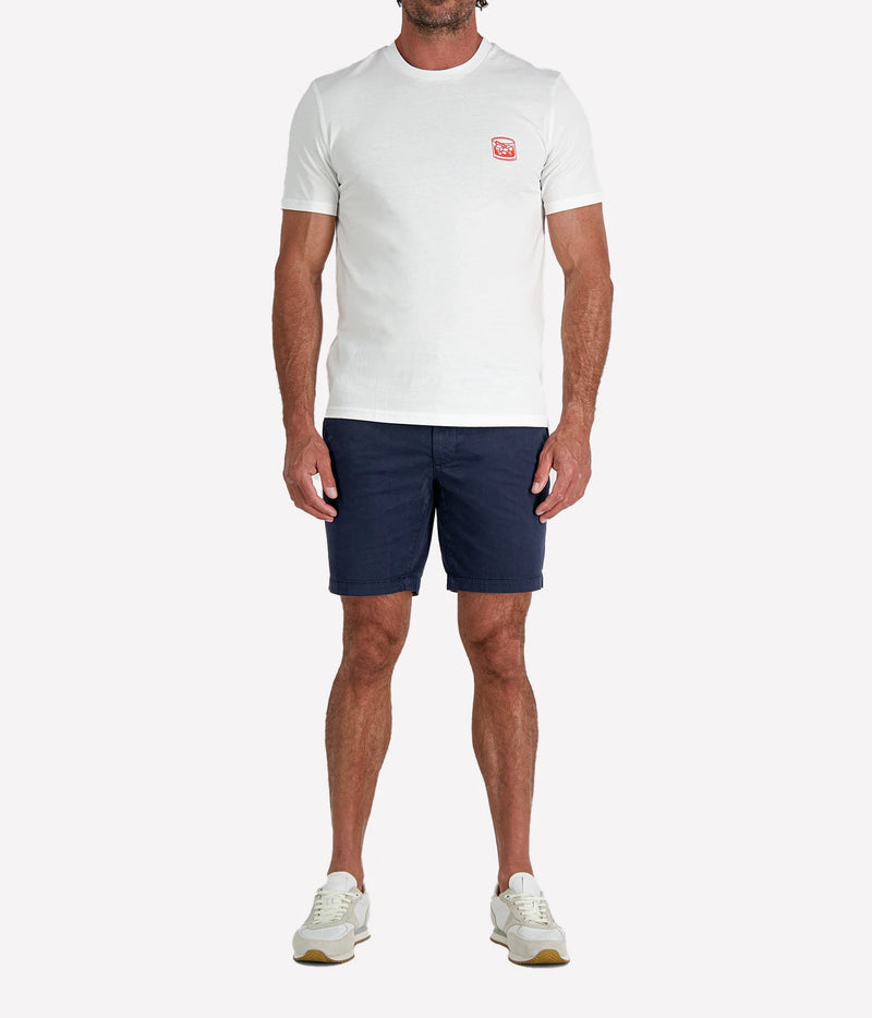 Man wearing The Refined Spirit Negroni Cocktail Bar Tee in White with navy shorts and white sneakers, full-length front view