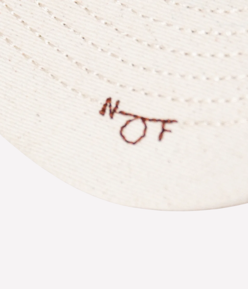 Nick Fouquet sailing flags cap – natural cotton twill with embroidered sailing flags and birds, brown leather strap, and braided rope detail.