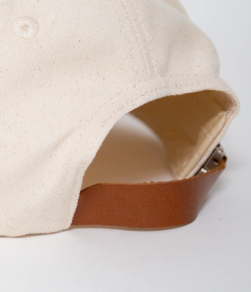 Nick Fouquet sailing flags cap – natural cotton twill with embroidered sailing flags and birds, brown leather strap, and braided rope detail.