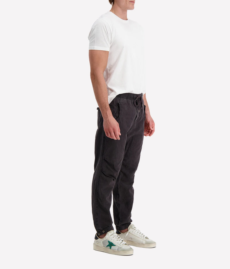 Textured cotton hemp flight pants in a relaxed fit, featuring a button fly, cuffed leg opening, knee tuck details, and snap button flap pockets. Crafted from breathable Italian cotton hemp with a unique textured finish.