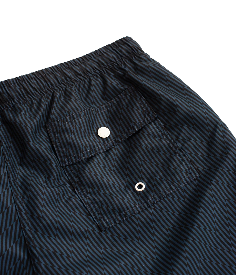Bather’s geometric swim trunks feature a bold, monochromatic herringbone-inspired pattern, reminiscent of retro ‘60s design. With a 5.5” inseam, reinforced pockets, and a back snap pocket, these quick-dry swim shorts are crafted from 100% recycled polyester for a stylish and sustainable fit.