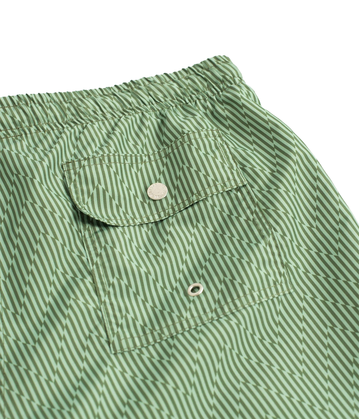 Bather’s geometric swim trunks feature a bold, monochromatic herringbone-inspired pattern, reminiscent of retro ‘60s design. With a 5.5” inseam, reinforced pockets, and a back snap pocket, these quick-dry swim shorts are crafted from 100% recycled polyester for a stylish and sustainable fit.