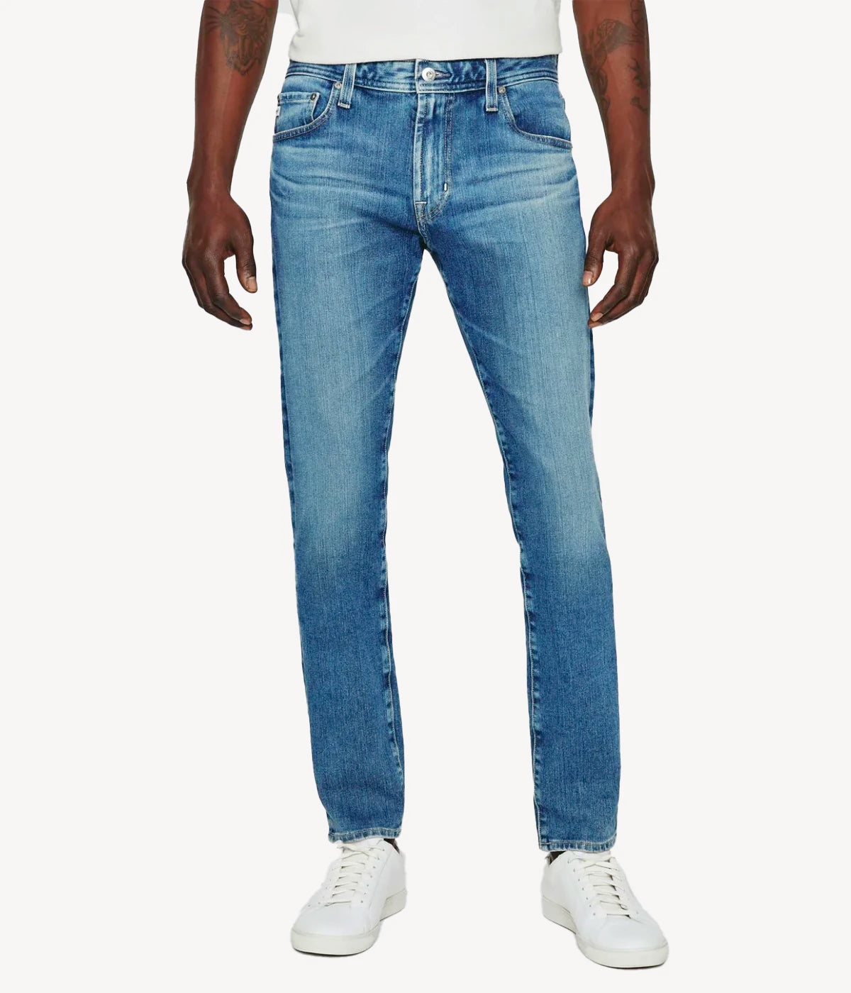 Men's Dylan slim skinny jeans in medium indigo wash, featuring carefully faded and whiskered details. The jeans are cut slim through the thighs and tapered at the ankle for a stylish, comfortable fit, offering both form and function.
