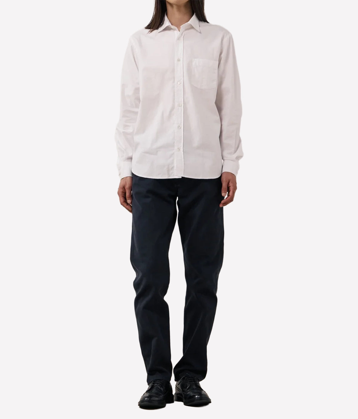 A model wearing a light off-white long-sleeve button-up shirt and dark navy pants.