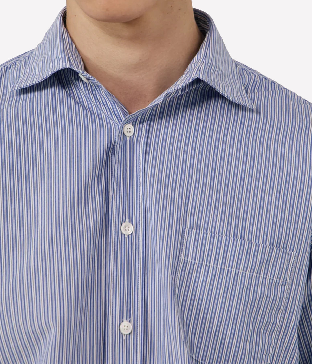 Close-up of a men's button-down shirt with a blue and white vertical stripe pattern, featuring a collar, white buttons, and a chest pocket.
