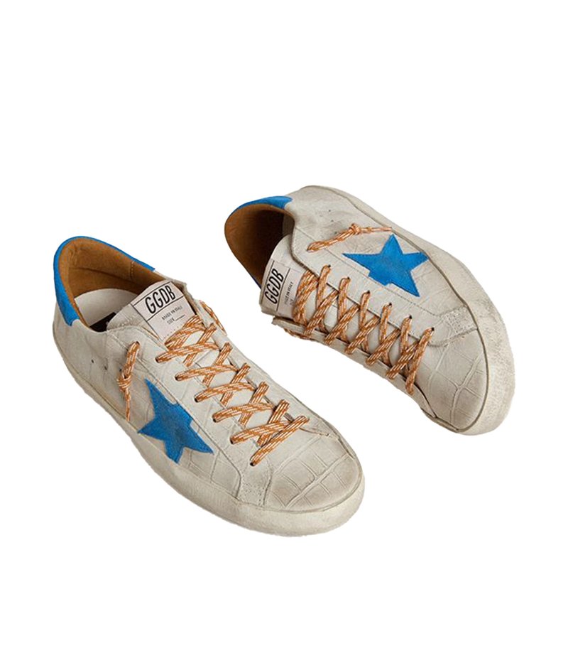 Golden Goose Superstar sneakers with white crocodile-embossed leather, blue suede star and heel tab, and distressed detailing. Made in Italy.