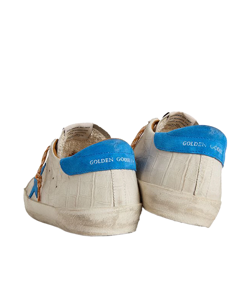 Golden Goose Superstar sneakers with white crocodile-embossed leather, blue suede star and heel tab, and distressed detailing. Made in Italy.