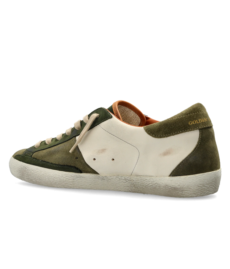 A Golden Goose sneaker in olive green suede and off-white leather, featuring a distressed off-white rubber sole and beige laces, shown from a side profile on a white background.