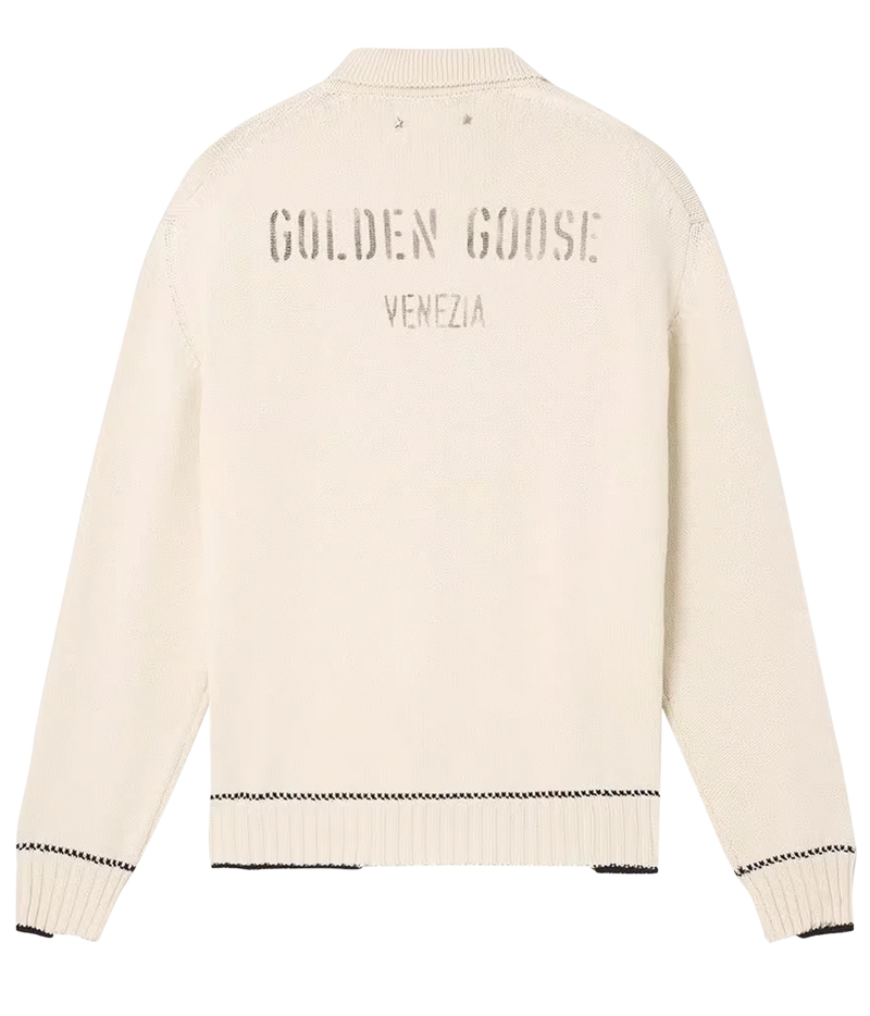 An off-white knit sweater shown from the back, featuring 'GOLDEN GOOSE VENEZIA' printed in a dark gray tone across the upper back, with ribbed cuffs and hem.