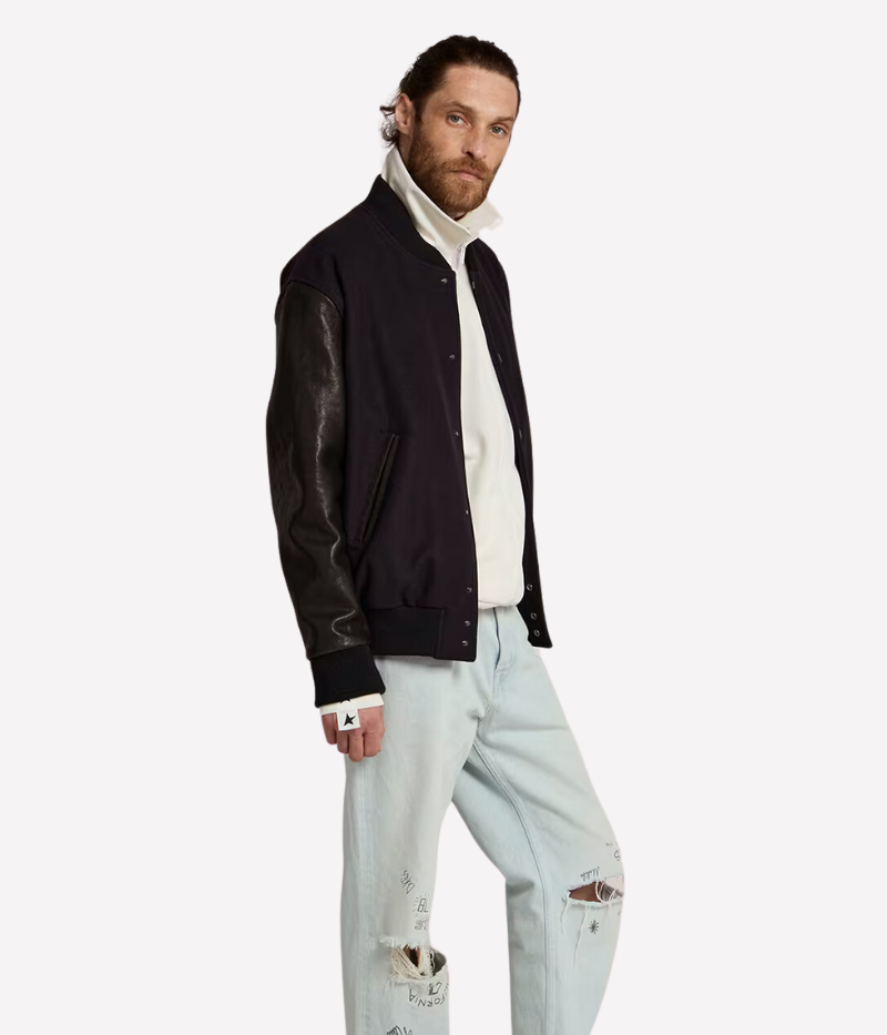 Golden Goose Golden Leather Bomber jacket in dark blue and black, featuring a wool blend body with distressed black leather sleeves and a signature double gold star detail on the back. Regular fit with button-up front, front pockets, and cotton lining for comfort. Crafted in Italy for a laid-back luxury look.