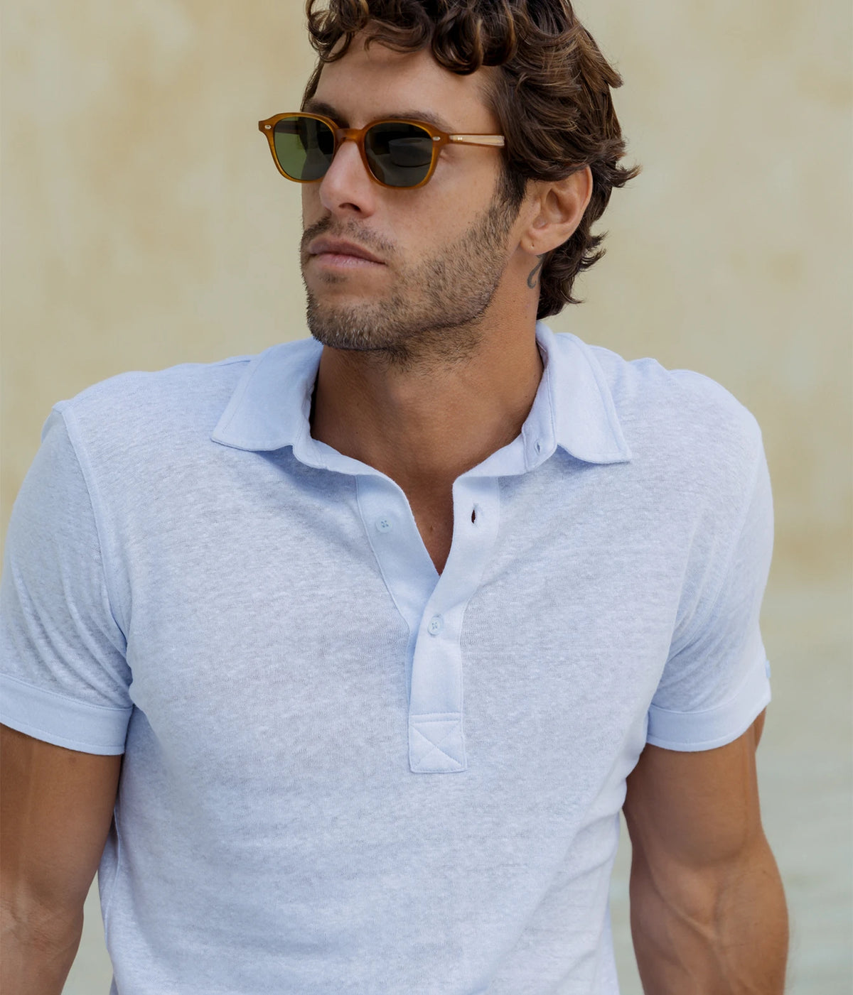 Man wearing Orlebar Brown Sebastian Tailored Linen Polo in Surfside Blue with sunglasses, front view