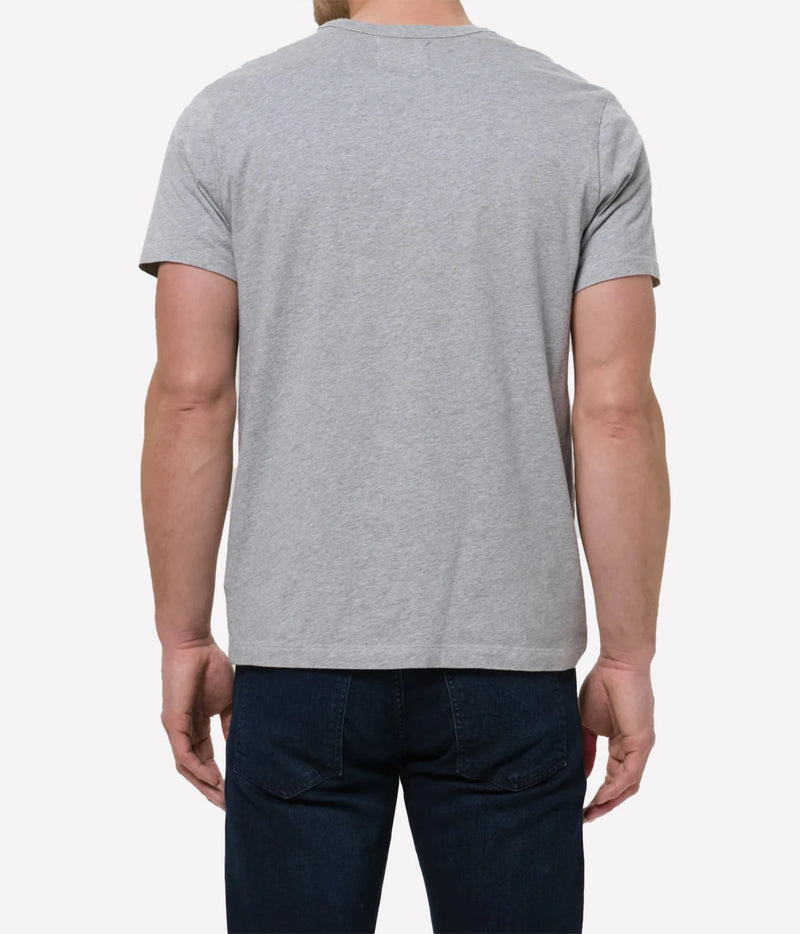 A man viewed from the back wearing a light grey heather crewneck t-shirt and dark blue jeans, set against a plain light grey background.