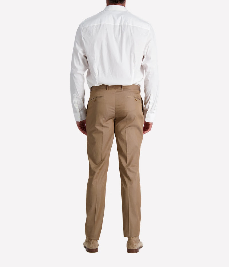 Model wearing a light brown Lardini cotton suit with a white shirt and suede loafers, featuring a single-breasted blazer with Lardini’s signature boutonnière, styled outdoors in a relaxed, modern setting.