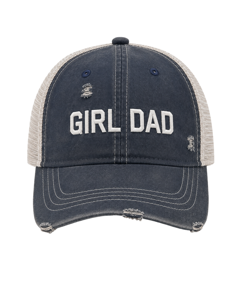 A distressed trucker-style baseball cap with a dark navy blue front panel and brim, and light beige mesh back panels. The front features the words 'GIRL DAD' embroidered in white block letters, with small distressed graphic details on the sides.