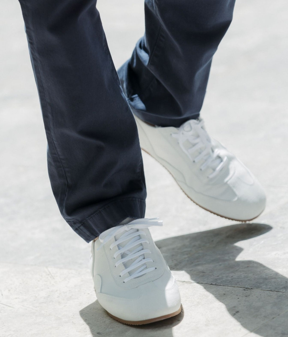 Model wearing Lardini Minimalist Wave Leather Sneaker in White with navy trousers