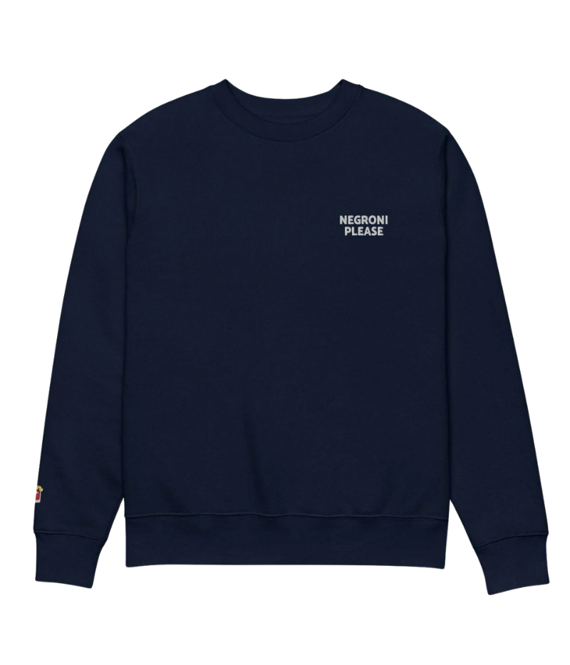 Navy unisex crewneck sweatshirt with "Negroni Please" graphic on chest and embroidered negroni icon on sleeve; features soft fleece lining and relaxed fit made from 100% organic cotton.