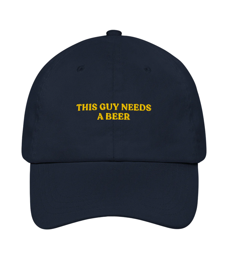 Navy blue cap with yellow text 'THIS GUY NEEDS A BEER' on a white background