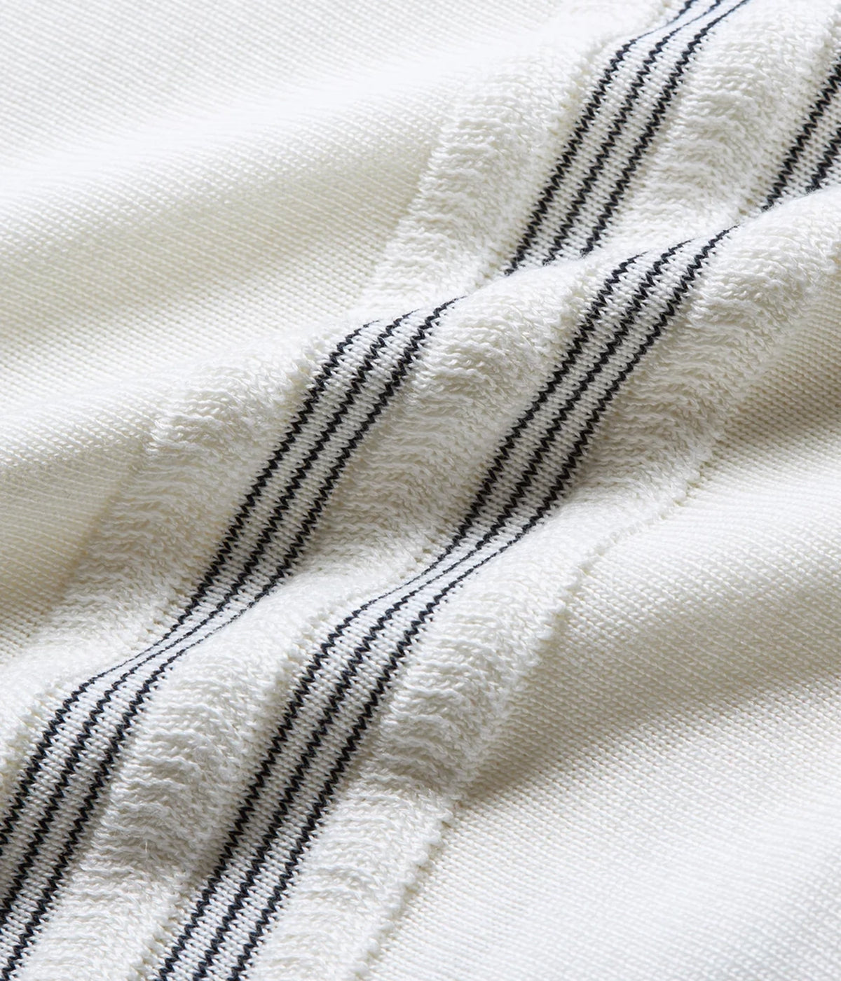 Close-up of Orlebar Brown Horton Chevron Stripe Polo in White Sand & Night Iris showing the knit and stripe detail