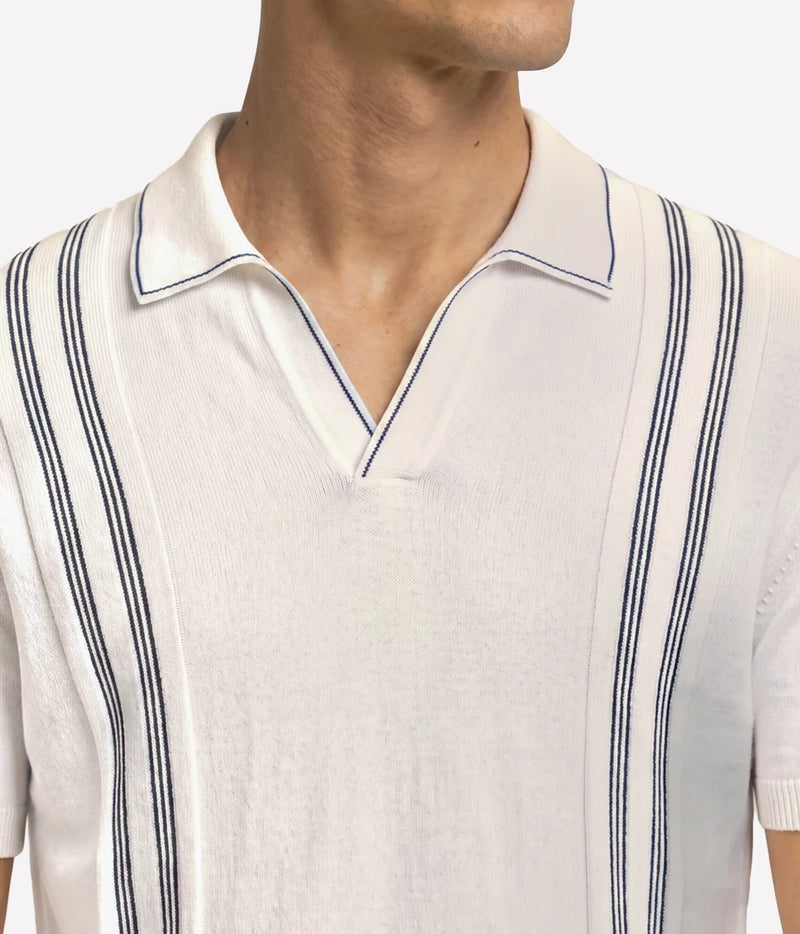 Close-up of Orlebar Brown Horton Chevron Stripe Polo in White Sand & Night Iris on model showing the chevron stripe front panel