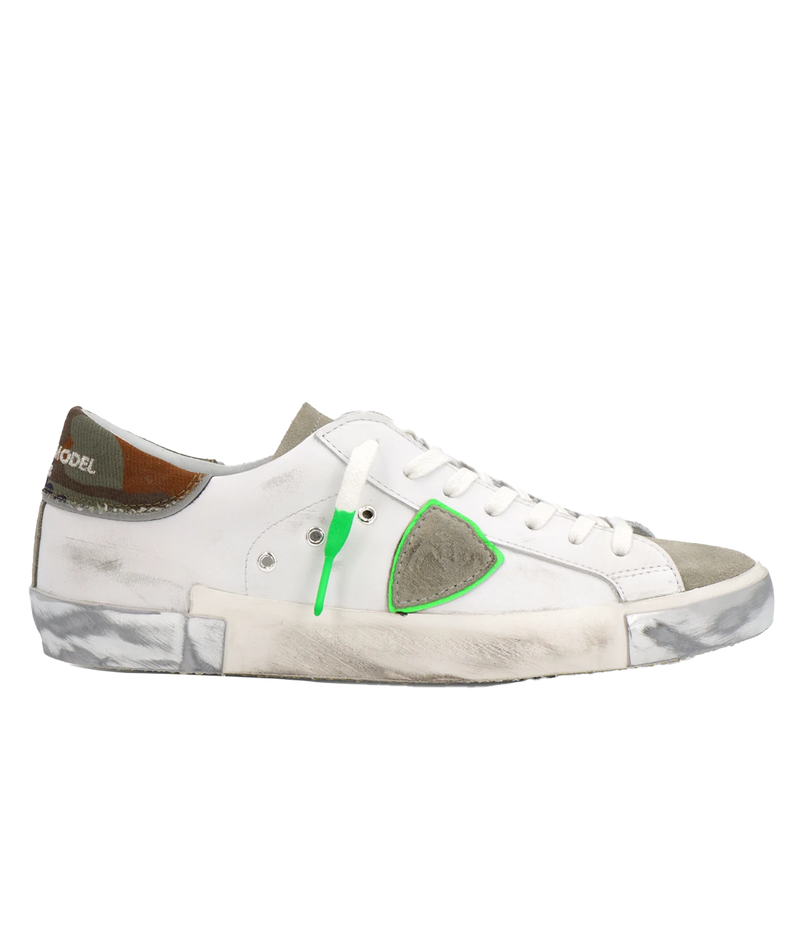 Side view of Philippe Model PRSX Low Man sneakers showcasing the unique vintage-effect design, with a patented foxing tape creating an imperfect sole. The shield on the side features the City of Paris coat of arms. The upper is crafted from high-quality Italian calfskin and suede, with laminated suede inserts.