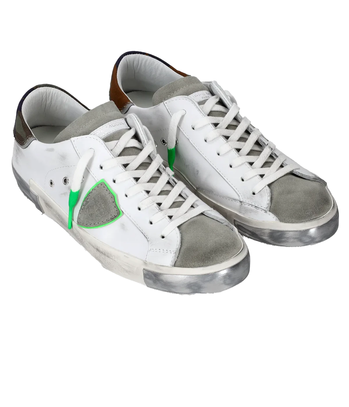 Angle view of Philippe Model PRSX Low Man sneakers, emphasizing the shield on the side of the shoe with the City of Paris coat of arms. The calfskin and suede upper has a worn, vintage-used effect, and the screen-printed laces add to the sneakers' timeless appeal.