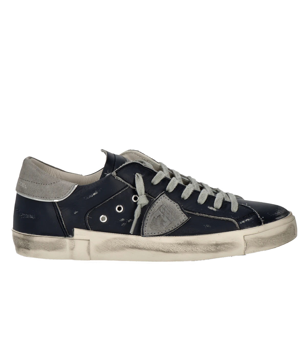 Side view of Philippe Model PRSX Low Man sneakers showcasing the unique vintage-effect design, with a patented foxing tape creating an imperfect sole. The shield on the side features the City of Paris coat of arms. The upper is crafted from high-quality Italian calfskin and suede, with laminated suede inserts.
