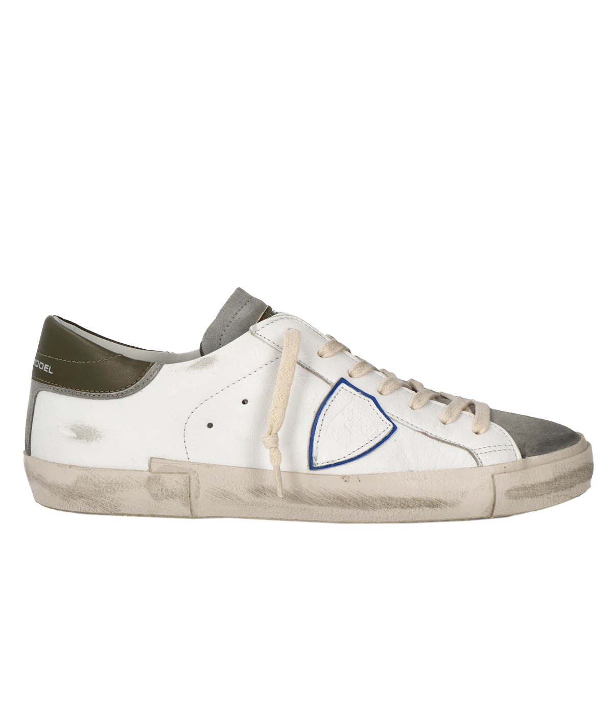 Side view of Philippe Model PRSX Low Man sneakers showcasing the unique vintage-effect design, with a patented foxing tape creating an imperfect sole. The shield on the side features the City of Paris coat of arms. The upper is crafted from high-quality Italian calfskin and suede, with laminated suede inserts.