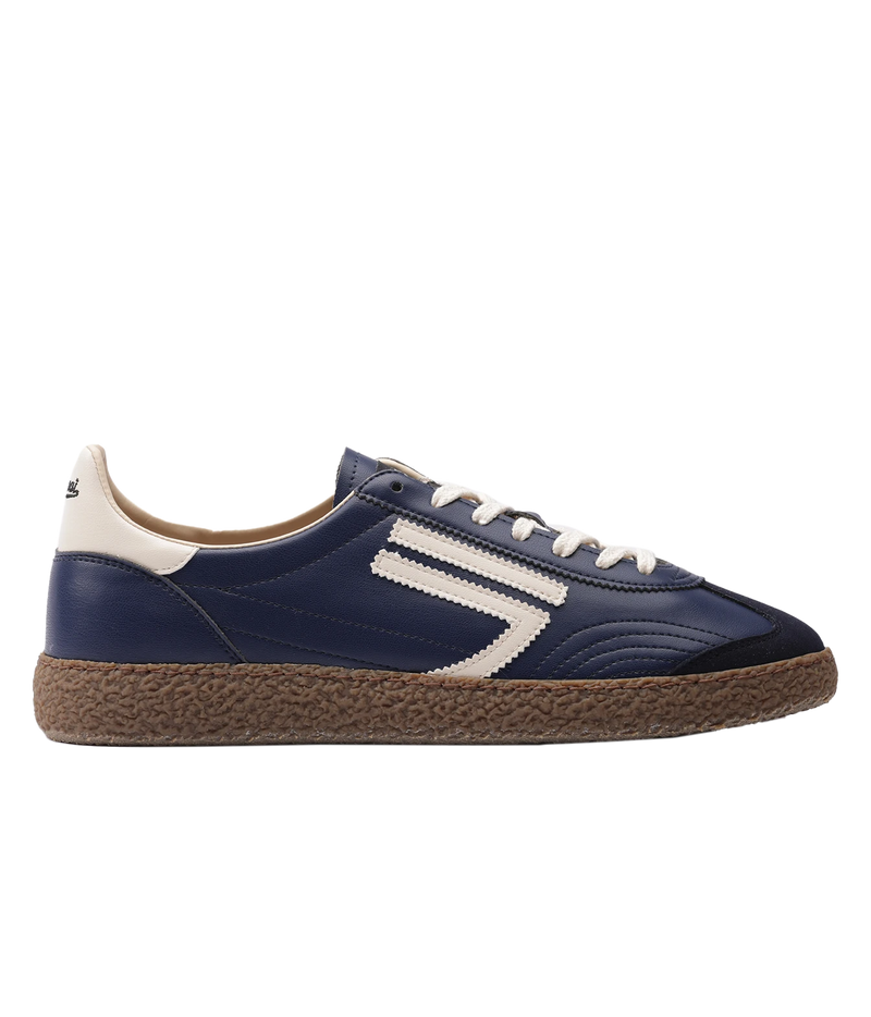 A navy blue sneaker with a textured brown sole, featuring a white side stripe design, white laces, and a cream heel tab.