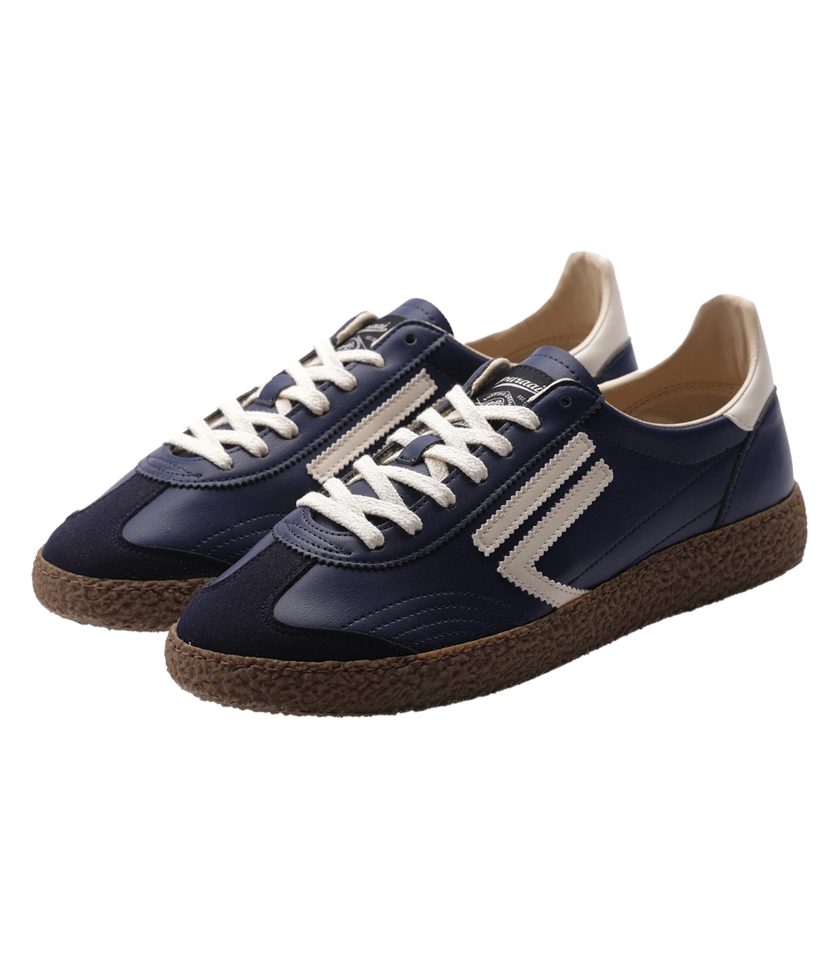 A pair of low-top sneakers in navy blue , featuring off-white laces, off-white side stripes, a beige heel tab, and brown textured espadrille-style soles, shown on a plain white background.