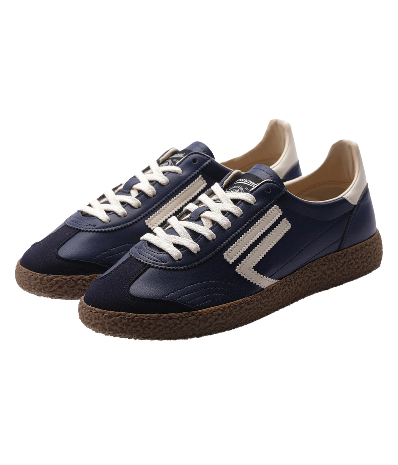 A pair of low-top sneakers in navy blue , featuring off-white laces, off-white side stripes, a beige heel tab, and brown textured espadrille-style soles, shown on a plain white background.