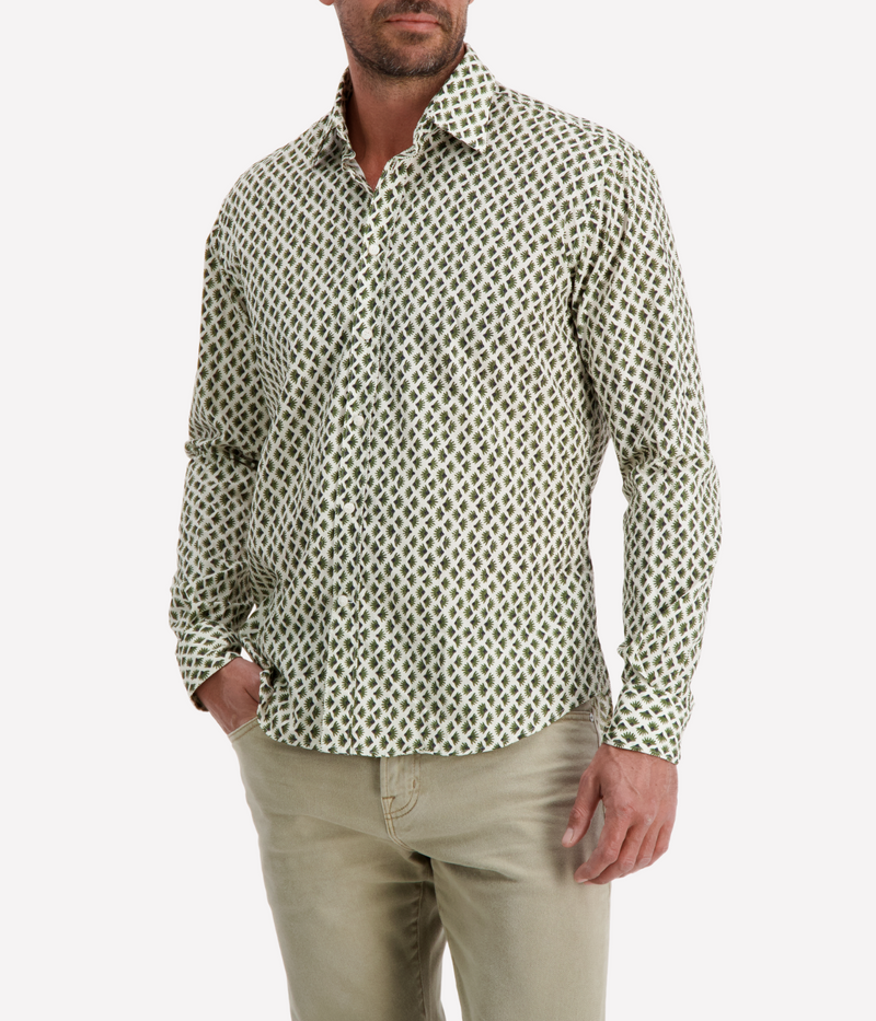 Man wearing a patterned shirt and beige pants on a white background