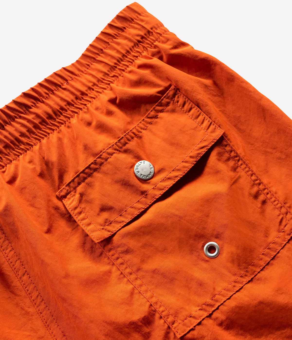 Orange Bather swim trunk for men featuring quick-dry recycled nylon, elastic waist, 5.5-inch inseam, mesh lining, and side pockets – luxury men’s swimwear Canada.