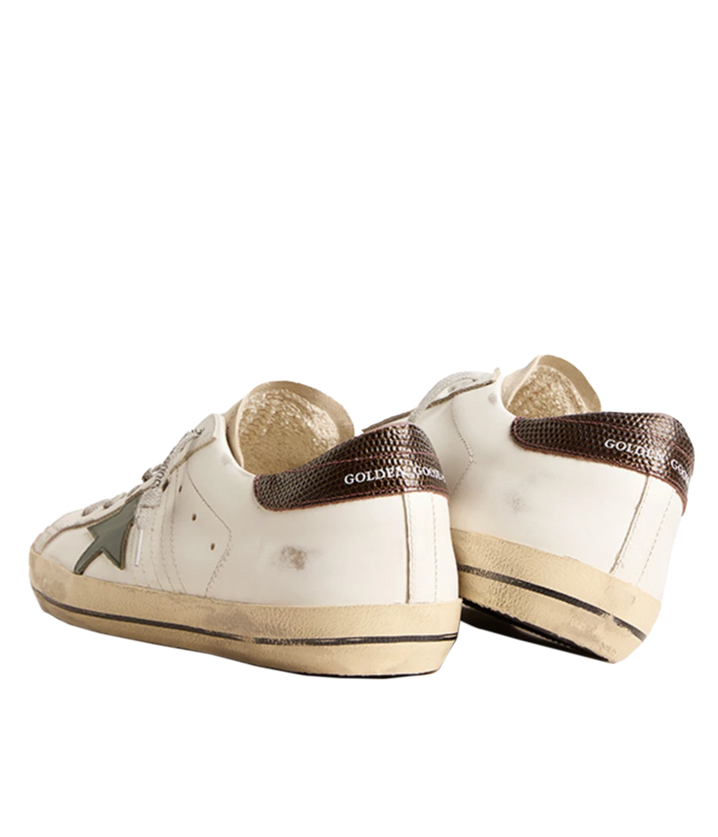 A pair of Golden Goose Super Star Sneakers in white, seed pearl, green, and brown, featuring the brand's signature distressed finish for a relaxed, worn-in look. The sneakers include a signature star patch on the sides and a contrasting green and brown heel counter. Designed with a front lace-up fastening, round toe, and flat rubber sole, these sneakers are perfect for everyday wear, offering a mix of style, comfort, and signature Golden Goose flair.