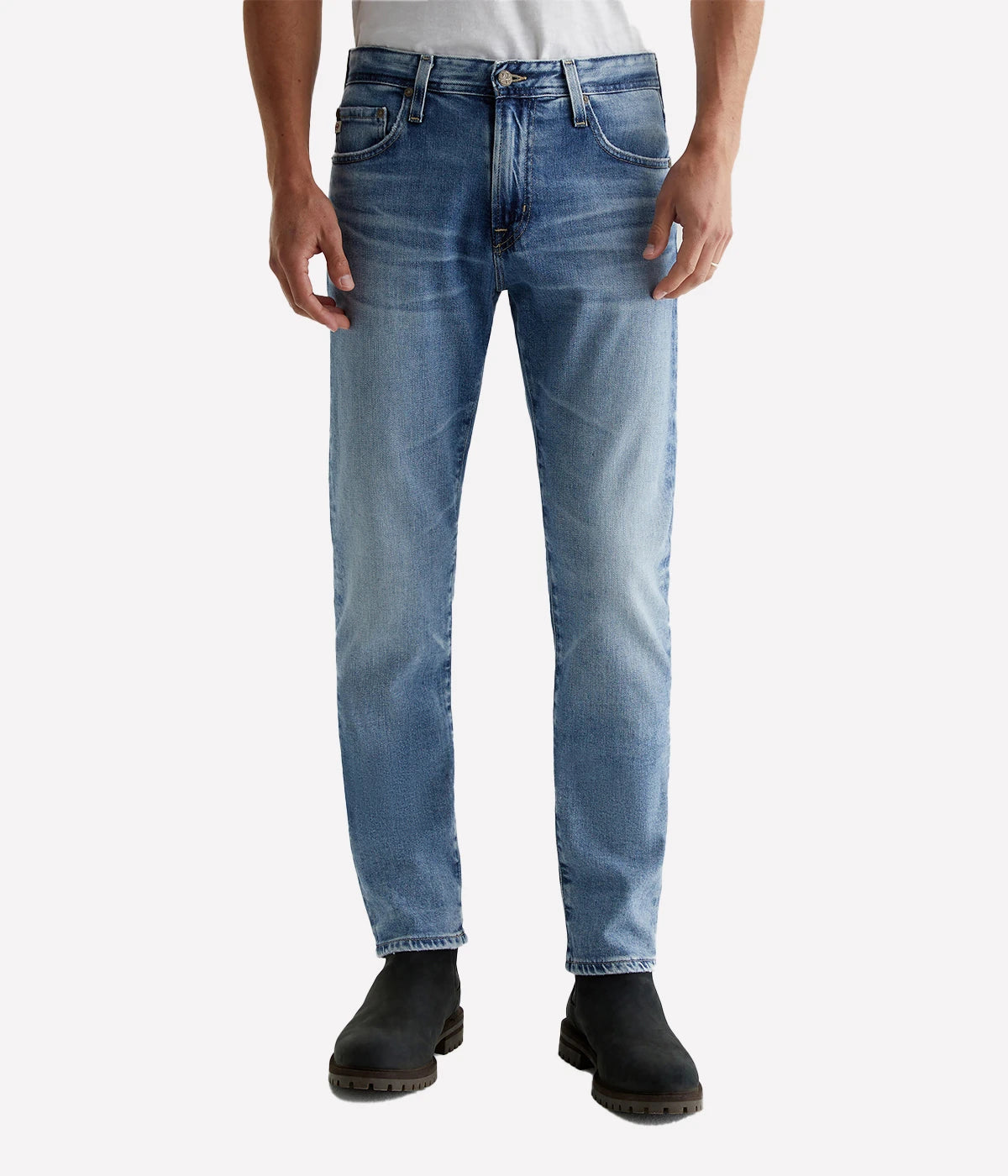 Tellis Modern Slim Jean for men in a medium blue wash, faded to a lighter shade with whiskering and crease marks that mimic the look of authentic vintage jeans aged over 21 years. Featuring a fitted upper block and tapered leg opening for a sleek, contemporary fit.