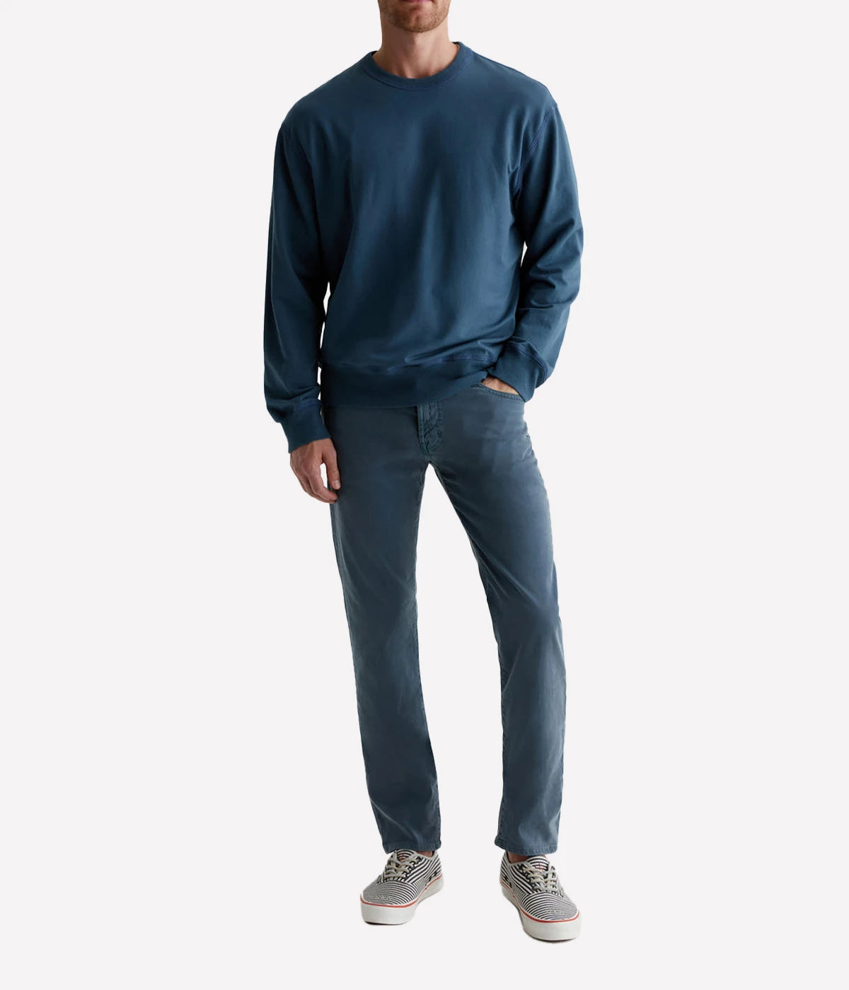 AG Tellis Slim Fit pants in a sulfur-dyed dark blue shade, featuring a fitted upper block and tapered leg. Crafted from lightweight Sueded Stretch Sateen from Italy, these five-pocket men's pants offer refined style and exceptional comfort. Measurements include a 10" front rise, 15 3/4" knee opening, 13 3/4" bottom opening, and 34" inseam.