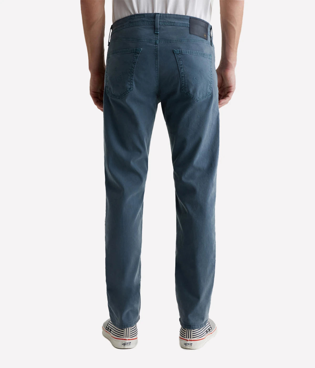 AG Tellis Slim Fit pants in a sulfur-dyed dark blue shade, featuring a fitted upper block and tapered leg. Crafted from lightweight Sueded Stretch Sateen from Italy, these five-pocket men's pants offer refined style and exceptional comfort. Measurements include a 10" front rise, 15 3/4" knee opening, 13 3/4" bottom opening, and 34" inseam.