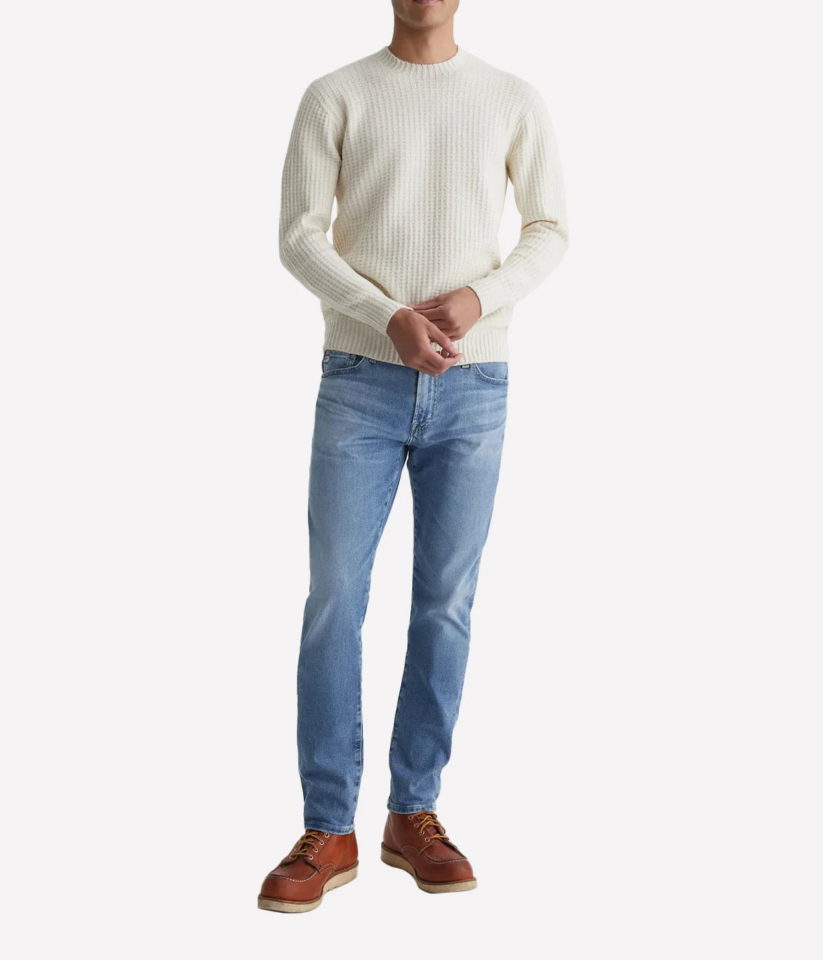 AG Tellis slim-fit jeans for men in a 16-year AG-ed™ light blue, featuring tapered leg opening and fitted upper block. Crafted from 9.4 oz. Hyper Soft Indigo Denim with AG's Cloud Soft Denim™ and dual-elastic performance fibres for a soft, stretchy feel